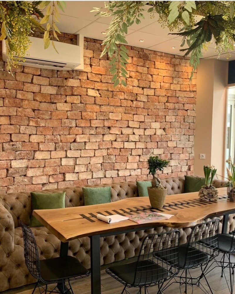 meuble pour professionnel, canapé marron, table à manger en bois et métal, accompagnée de chaises en métal, ambiance moderne et industrielle